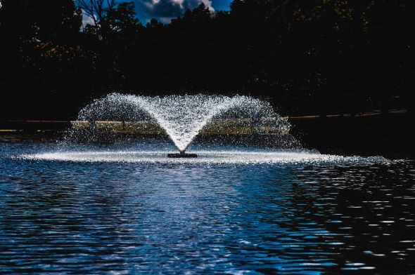 Photo of a water fountain gushing water into a lake